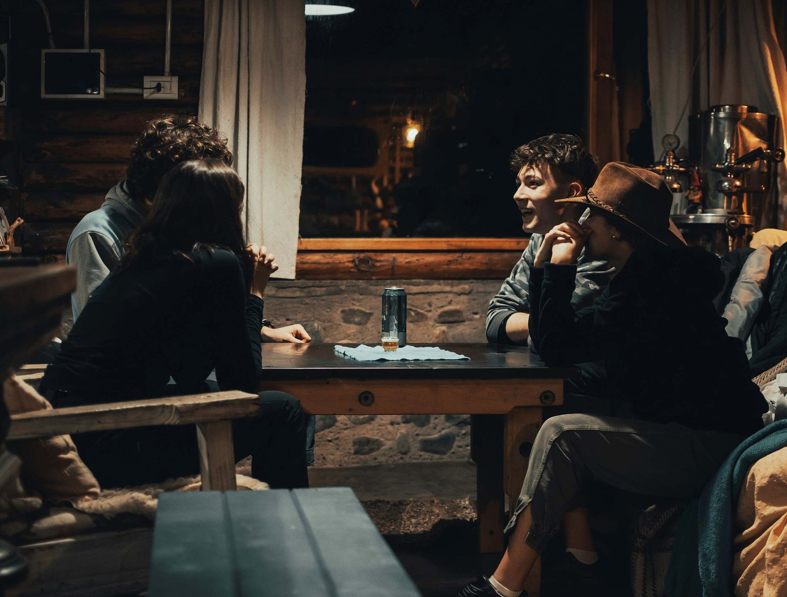 Guests gathered around a wooden table inside a warmly-lit cabin